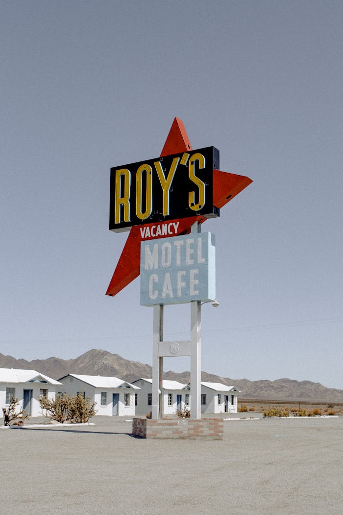 Iconic Roy's Motel sign in a deserted landscape under clear skies.